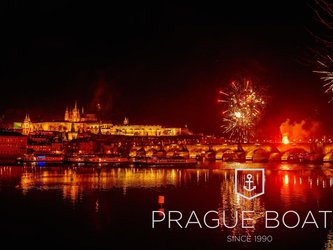 en:The city of Prague lit up by red fireworks, with the river flowing beneath the bridge; fr:Ville de Prague sous les feux d'artifice en rouge avec le fleuve qui passe en dessous du pont