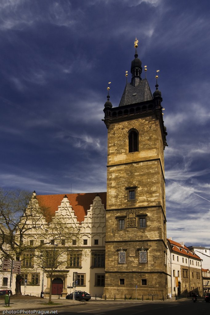 Large old stone tower with its pointed black tile roof.